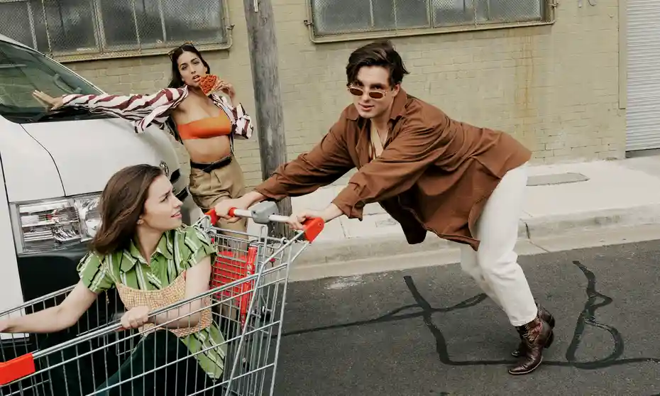 Chico empujando carrito con chica