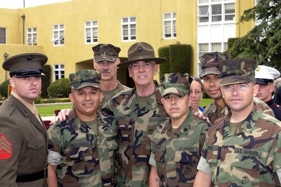 R. Lee Ermey (centro), ascendido honoríficamente a sargento de artillería de los Marines (foto oficial USMC, dominio público)