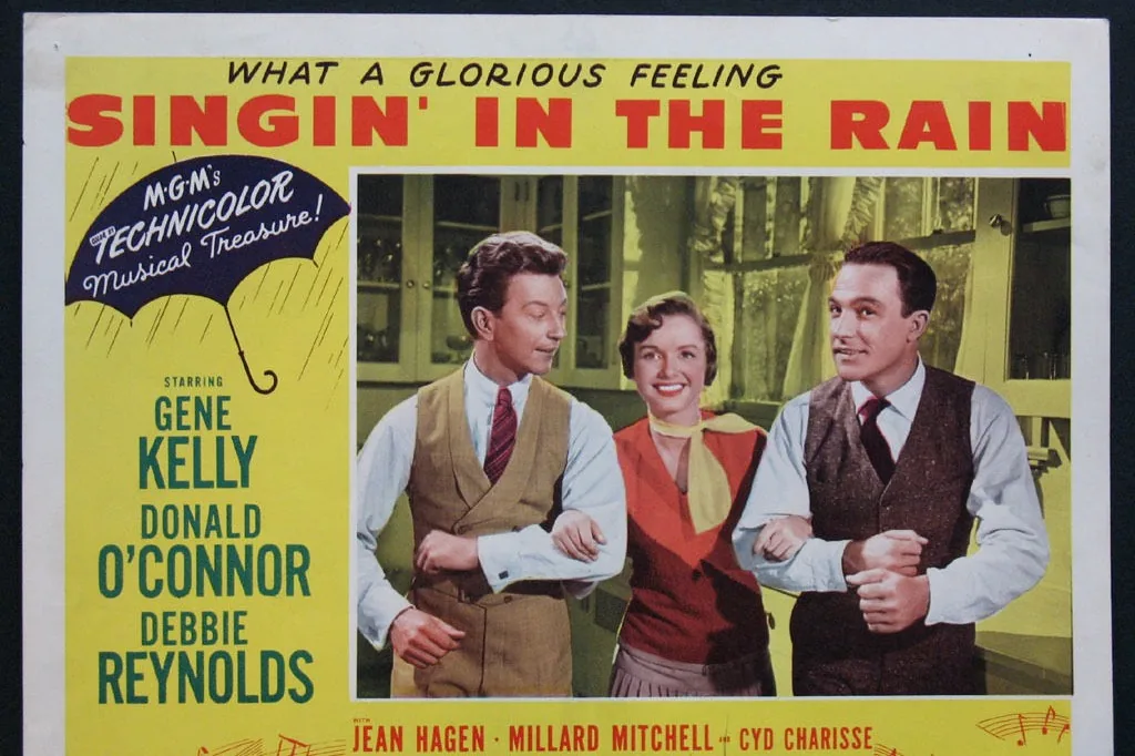Cartel de sala (lobby card) original de 'Cantando bajo la lluvia' (1952), MGM (dominio público)